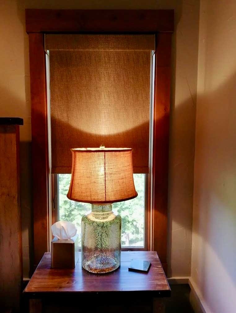 Lamp on a table in front of a covered window